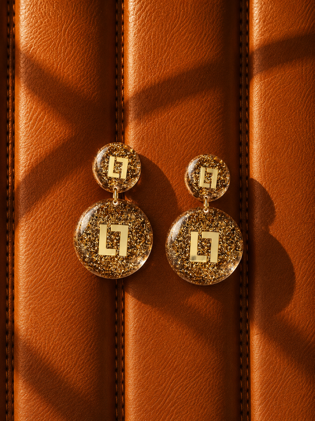 Gouden Glitter Oorbellen Larissa Logo