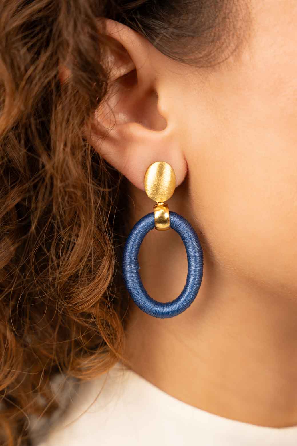Blue oval earrings threaten S Faye